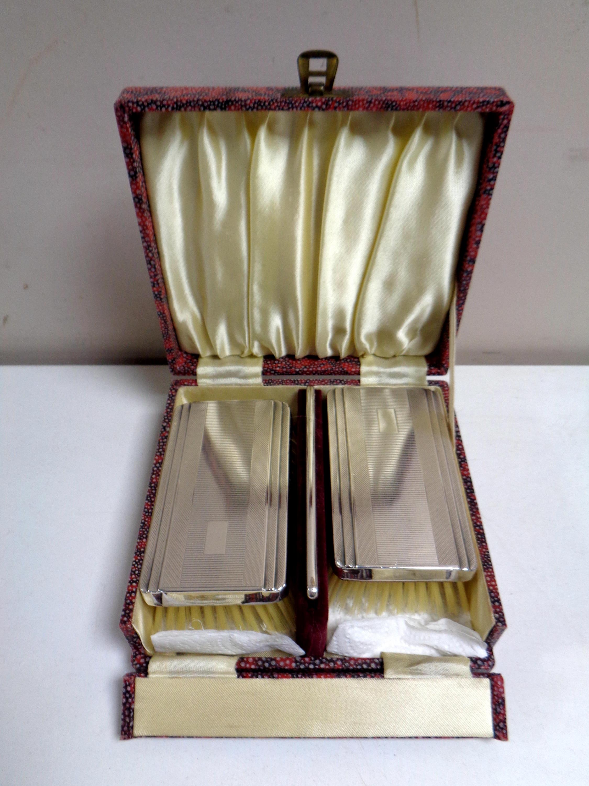 A cased three piece Birmingham silver-backed brush and comb set