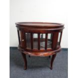 A reproduction oval drinks cabinet with lift off tray on raised legs