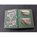 An Edwardian postcard album containing a large quantity of colour and monochrome postcards to