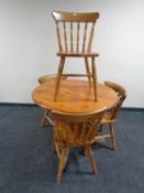 A circular pine pedestal kitchen table together with four chairs