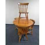 A circular pine pedestal kitchen table together with four chairs