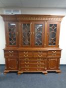 A reproduction Victorian style four door bookcase fitted secretaire cupboards and drawers beneath