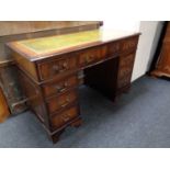 A Regency style twin pedestal writing desk fitted nine drawers with a green tooled leather inset