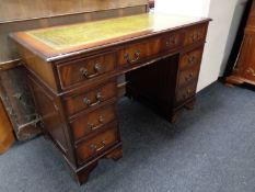 A Regency style twin pedestal writing desk fitted nine drawers with a green tooled leather inset