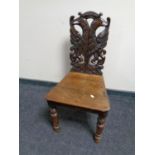 A Victorian heavily carved oak hall chair