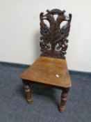 A Victorian heavily carved oak hall chair
