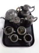 A tray containing a four piece antique English pewter tea service together with further plated