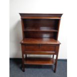 An Edwardian mahogany cabinet on raised legs fitted shelves above