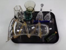 A tray containing antique and later glassware to include green glass bottle, hand bells,