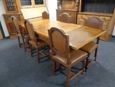 An early 20th century oak pull out dining table with checker board inlaid top on a heavily carved