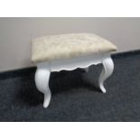 A contemporary dressing table stool on painted legs