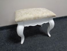 A contemporary dressing table stool on painted legs