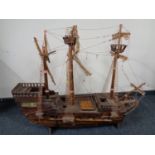 A hand built wooden model of a three masted galleon on stand