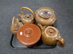 A tray containing antique and later pottery to include three teapots and two lidded storage jars