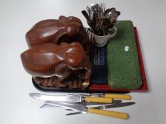 A tray containing wooden elephants together with a large quantity of stainless steel and plated