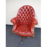 A red button leather Chesterfield high backed swivel office armchair