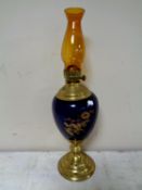 A Duplex brass and porcelain oil lamp with amber glass chimney