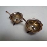 A pair of silver salts with spoons