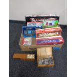 A box containing assorted board games, battery operated transporter, brain trainer, dominoes,