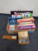 A box containing assorted board games, battery operated transporter, brain trainer, dominoes,