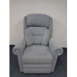 An electric reclining high backed armchair upholstered in a grey fabric