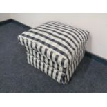 A footstool upholstered in a checkered fabric