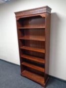 A set of open bookshelves in a mahogany finish