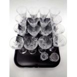A tray containing a set of sixteen wine glasses together with two cut glass vases