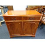 An inlaid yew wood double door cabinet fitted two drawers