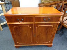 An inlaid yew wood double door cabinet fitted two drawers