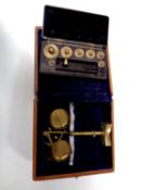 A miniature set of brass balance scales in a fitted box together with a set of miniature weights in