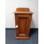 An antique pine bedside cabinet with ceramic handle