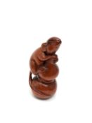 A carved Chinese hardwood netsuke - Rat holding a bag of grain