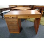 A mid century teak shutter fronted desk