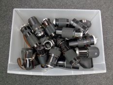 A plastic tub containing various cameras and lenses including Nikon,