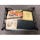 A crate containing cigarette card albums,