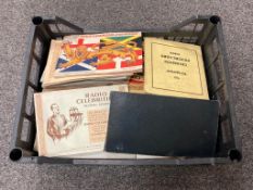 A crate containing cigarette card albums,