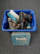 A plastic crate containing various power tools including Makita drill,