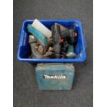 A plastic crate containing various power tools including Makita drill,