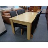 A contemporary light oak dining table and six black leather chairs