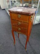 A continental inlaid walnut three drawer bedside chest with marble top