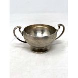 A small silver twin handled cup,