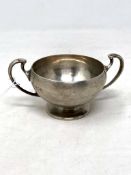 A small silver twin handled cup,