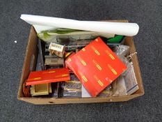 A box containing a collection of model railway accessories including buildings,