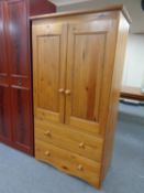 A pine double door hanging wardrobe fitted two drawers
