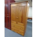 A pine double door hanging wardrobe fitted two drawers