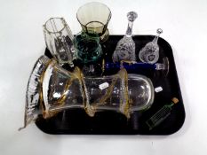 A tray containing antique and later glassware to include green glass bottle, hand bells,