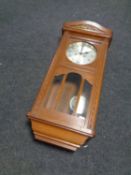 An Edwardian oak wall clock with pendulum