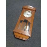 An Edwardian oak wall clock with pendulum