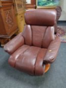 A brown leather revolving and reclining armchair